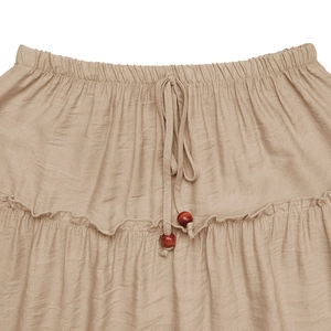 Detail of elastic waist with drawstring, wooden beads, and ruffled tiers on khaki skirt