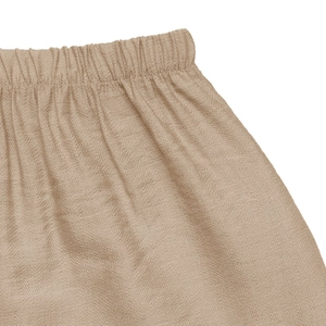 Detail view of the elastic waist and textured khaki fabric on the A-line skirt