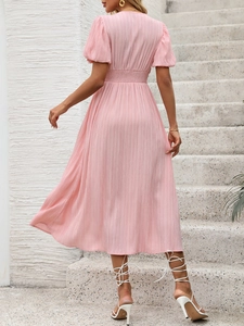 Détail du dos d'une robe rose texturée à col en V avec manches lanternes et taille élastique