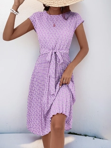 Detailed view of summer dress featuring purple floral print, short sleeves and waist tie