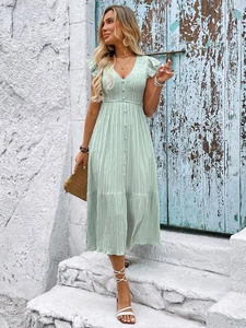 Detailed macro view of the light green pleated texture and V-neckline of this summer dress