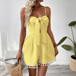 Yellow sleeveless romper with bow tie, textured fabric and fringe hem for summer