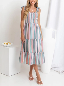 Detail of colorful rainbow striped sundress with bow-tie straps and tiered ruffle skirt