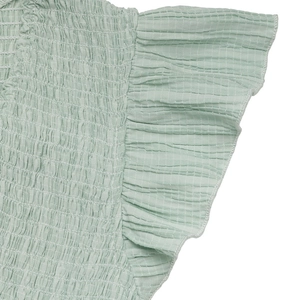 Detail of light green smocked bodice with ruffled edges and micro-check texture fabric