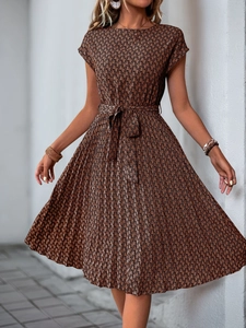 Detail view of brown textured geometric print pleated dress with adjustable waist tie
