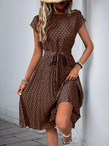 Detail of a brown geometric print pleated dress with waist tie and short sleeves