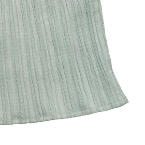 Close-up of light green textured seersucker fabric with neat hem stitching details