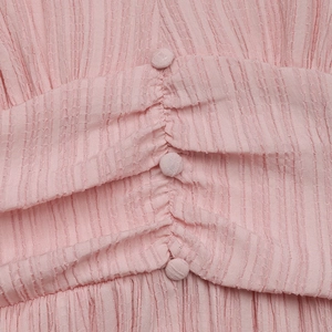Détail de robe rose avec tissu seersucker texturé et boutons recouverts assortis