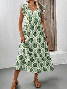 Détail du col en V et des manches à volants sur une robe bohème blanche à motifs verts