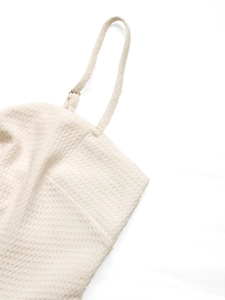 Detailed view of beige waffle knit fabric with adjustable strap and metal buckle