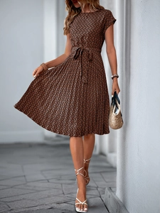 Detail of elegant pleated dress featuring vintage brown geometric print and tie waist belt