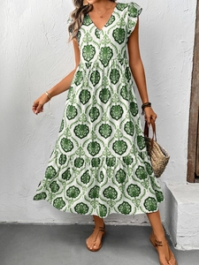 Détail de l'encolure en V et de l'imprimé ethnique vert sur la robe longue d'été blanche