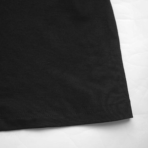 Détail de la couture à double aiguille sur l'ourlet de la robe noire ethnique en tricot