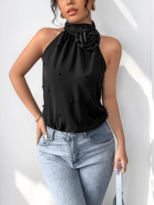 Détail d'un body dos nu noir avec fleur 3D et décorations de perles élégantes