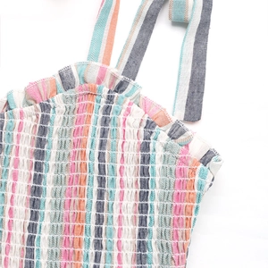 Detail of colorful rainbow striped dress with elastic smocking and ruffle trim