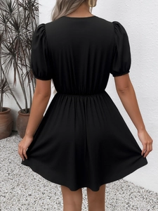 Gros plan sur la robe rétro noire à rayures avec taille ajustée et manches bouffantes