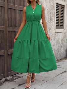 Détail de la robe verte à col en V avec boutons décoratifs blancs et jupon à étages