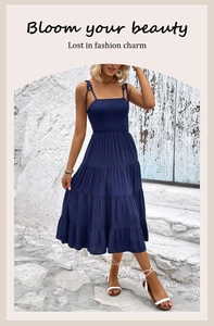Detail of navy blue smocked bodice and tiered hem on a summer midi sundress