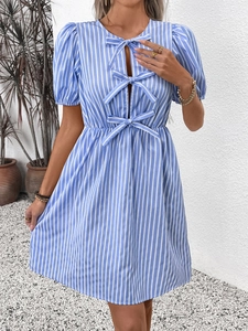 Détail d'une robe rayée bleu clair avec des découpes frontales et des nœuds décoratifs