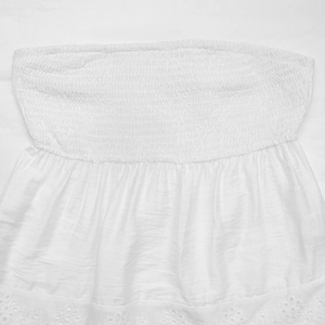 Detail of white y2k crop top featuring elastic smocked fabric and eyelet lace embroidery