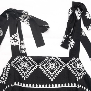 Détail d'une robe d'été à imprimé ethnique noir et blanc avec bretelles à nœuds