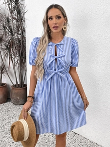 Détail de la robe à rayures bleues avec nœuds élégants et design ajouré chic