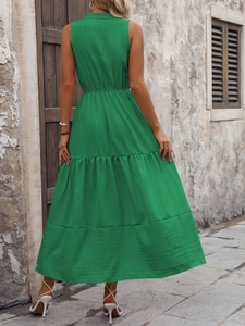 Détail d'une robe maxi verte sans manches avec texture plissée et jupe trapèze à volants