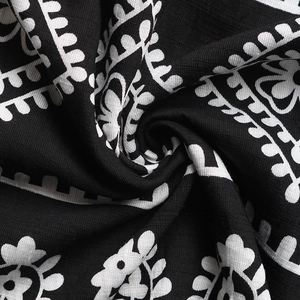 Détail du tissu à fleurs montrant la texture douce et le motif ethnique de la robe