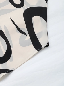 Detailed close-up showing black abstract geometric prints on beige summer blouse fabric