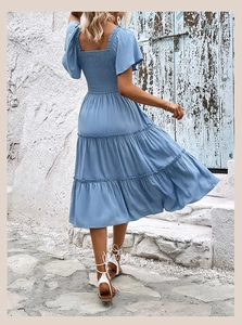 Vue arrière d'une robe mi-longue bleu clair à volants avec dos élastiqué et manches volantées