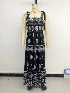 Détail de l'imprimé floral ethnique sur robe d'été longue à volants et nœuds d'épaules