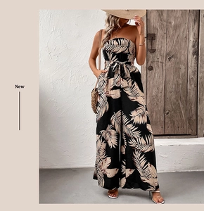 Detail of tropical palm leaf print on black strapless wide-leg jumpsuit with waist tie