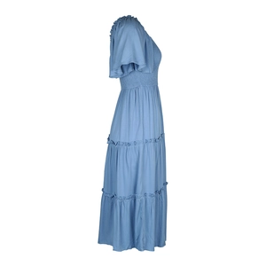 Détail du corsage froncé et des manches à volants sur une robe d'été bleu ciel à volants