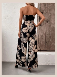 Back view of summer strapless wide-leg jumpsuit with tropical beige leaf print on black fabric