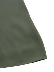Gros plan du tissu sergé vert olive et couture fine de l'ourlet sur la robe d'été