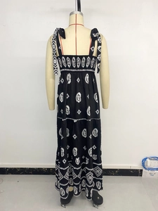 Détail d'une robe bohème noire et blanche avec jupe à volants et bretelles