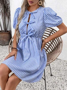 Détail de la robe à rayures bleues et blanches avec manches bouffantes et nœuds