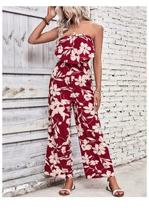 Detail of red floral off-shoulder jumpsuit featuring ruffled bust and wide leg cut