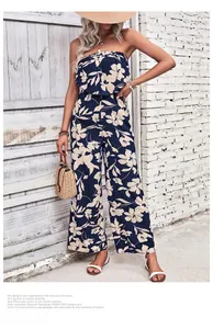 Navy floral off-shoulder jumpsuit styled with straw accessories for a summer vacation look