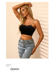 Detail des schwarzen Crop-Tops mit schicken Metallketten-Trägern und Falten-Design