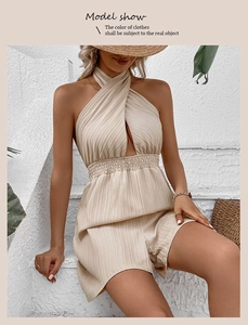 Detail eines beigen Falten-Jumpsuits mit schickem überkreuztem Neckholder und hoher Taille