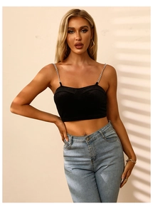 Detail eines schwarzen Crop-Tops mit silbernen Kettenträgern und Herz-Ausschnitt-Design
