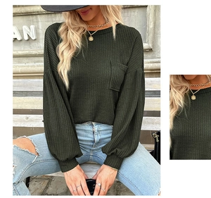 Detail of waffle knit fabric texture and pocket on this green long sleeve crewneck top