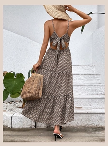 Detail of backless floral maxi dress featuring a chic tie-back bow and geometric chain print