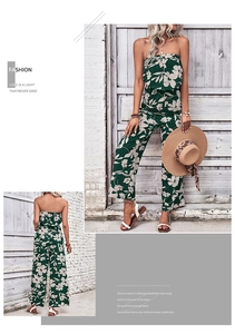 Detailed view of floral off-shoulder top and high-waisted wide-leg trousers in dark green
