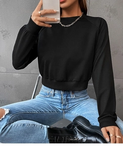 Close-up of black cropped sweatshirt featuring wide ribbed cuffs and crew neck detail