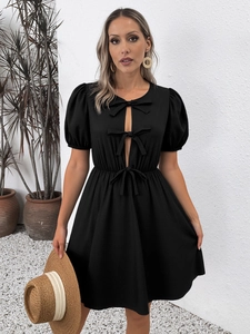 Détails des manches bouffantes et découpe frontale avec nœuds décoratifs sur robe noire