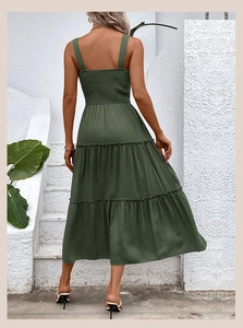 Vue arrière d'une robe verte olive à volants et dos smocké sur des marches blanches