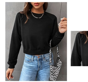 Detail view of black cropped sweatshirt with raglan sleeves and ribbed crew neck finish