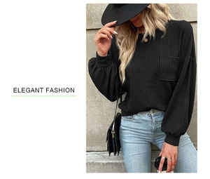 Detail of black waffle knit texture on long sleeve top with chest pocket and lantern sleeves